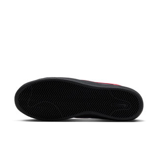 Black rubber outsole of Nike SB Tennis Classic featuring herringbone traction pattern and molded Nike Swoosh.
