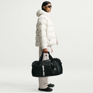 Nike ACG DAYMAX Duffel Bag in Black/College Grey with black carry handles, grey webbing straps, a front zippered pocket, and a small ACG logo