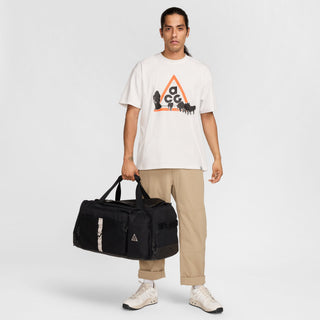 Nike ACG DAYMAX Duffel Bag in Black/College Grey with black carry handles, grey webbing straps, a front zippered pocket, and a small ACG logo