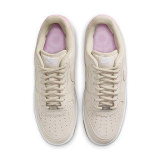 Pair of beige sneakers with pink interior on a white background