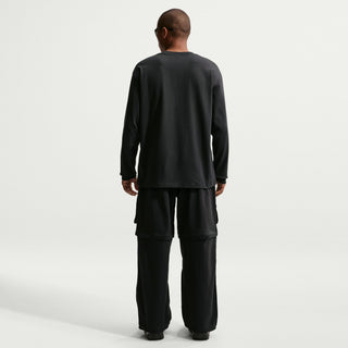 Model wearing black Nike ACG Smith Summit Zip Cargo Pants with a loose fit, large thigh cargo pockets, and zip-off leg panels

