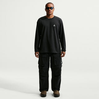 Model wearing black Nike ACG Smith Summit Zip Cargo Pants with a loose fit, large thigh cargo pockets, and zip-off leg panels

