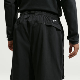 Model wearing black Nike ACG Smith Summit Zip Cargo Pants with a loose fit, large thigh cargo pockets, and zip-off leg panels

