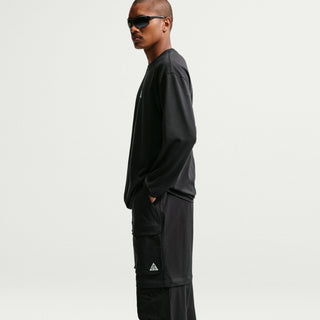 Model wearing black Nike ACG Smith Summit Zip Cargo Pants with a loose fit, large thigh cargo pockets, and zip-off leg panels

