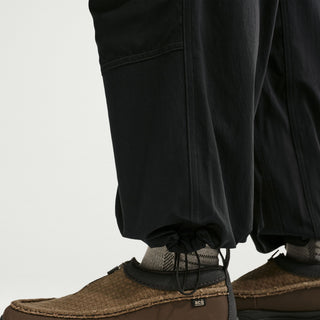 Model wearing black Nike ACG Smith Summit Zip Cargo Pants with a loose fit, large thigh cargo pockets, and zip-off leg panels

