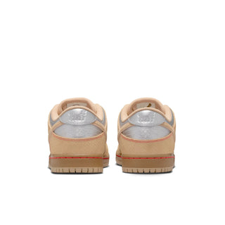 Pair of tan sneakers with red accents on a white background