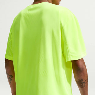 Person wearing a bright green t-shirt on a plain background