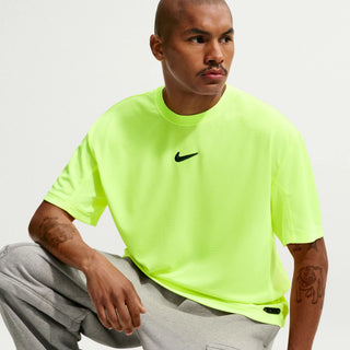Person wearing a bright yellow Nike t-shirt and gray pants.