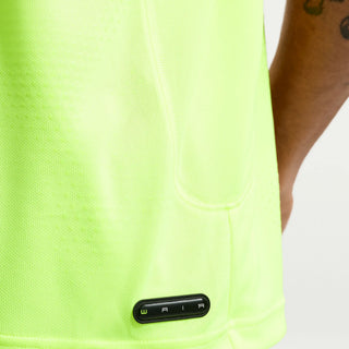 Close-up of a bright green sleeve with a black label on a person wearing a white shirt.