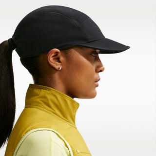 black Nike ACG Fly Unstructured Cap with a white embroidered ACG logo, holding the front of the bill.