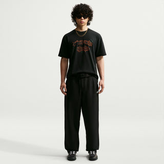 Rear view of a model wearing black Nike SB Men’s Skate Pants with a roomy, straight-leg silhouette