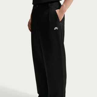Rear view of a model wearing black Nike SB Men’s Skate Pants with a roomy, straight-leg silhouette