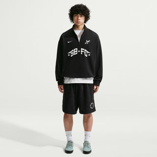 Person wearing a black tracksuit with visible branding on a white background