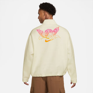 Person wearing a cream-colored jacket with a colorful design on the back against a white background
