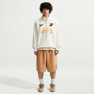 Person wearing a white sweatshirt with colorful text and graphics on a plain background