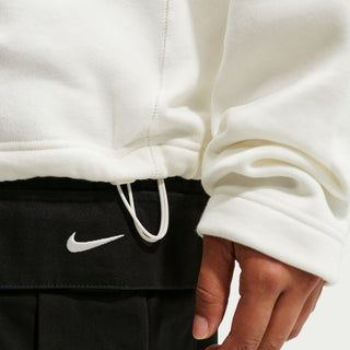 White hoodie with drawstring and black pants featuring a Nike logo.