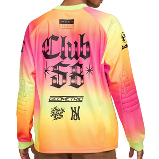 A long-sleeve athletic jersey shown from the back on a model, featuring a vibrant neon gradient transitioning from pink and orange to yellow and green. The back is decorated with black graphics, including 'Club 55' in a gothic font, sponsor logos, and quilted sleeve panels.