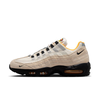Beige sneaker with black and yellow accents on a white background