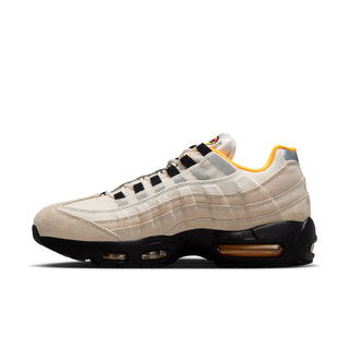 Beige sneaker with black and yellow accents on a white background