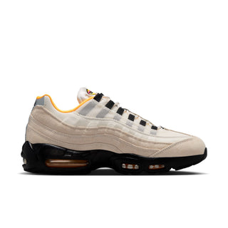 Beige sneaker with black and yellow accents on a white background