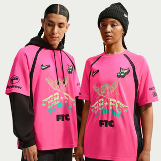 Person wearing a white sports jersey with various logos and text on a Hyper Pink Background