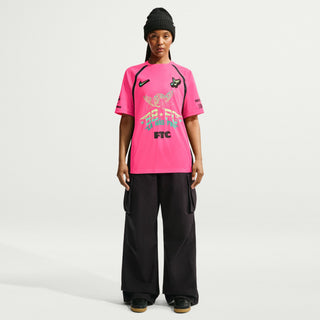 Person wearing a white sports jersey with various logos and text on a Hyper Pink Background