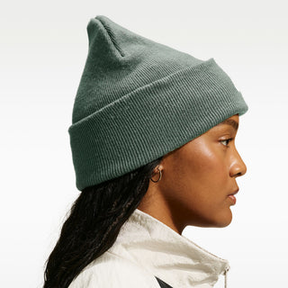 Model wearing the Nike SB Peak Skate Beanie in Camo Green with a folded cuff and white embroidered Nike SB logo