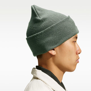 Model wearing the Nike SB Peak Skate Beanie in Camo Green with a folded cuff and white embroidered Nike SB logo