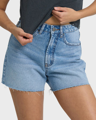 Person wearing light blue denim shorts on a white background