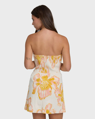 Woman wearing a strapless floral dress on a white background