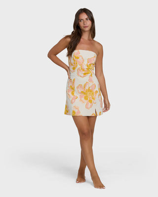 Woman wearing a strapless floral dress on a white background