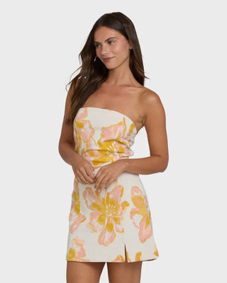 Woman wearing a strapless floral dress on a white background