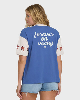 Woman wearing a blue and white t-shirt with 'forever on vacay' text and star designs.