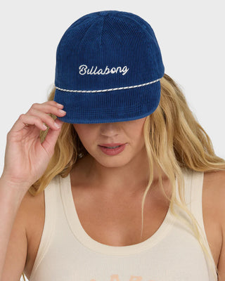 Woman wearing a blue cap with 'Billabong' logo on a white background