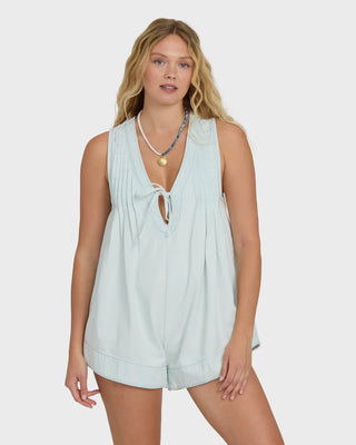 Woman wearing a light blue sleeveless top and shorts on a white background