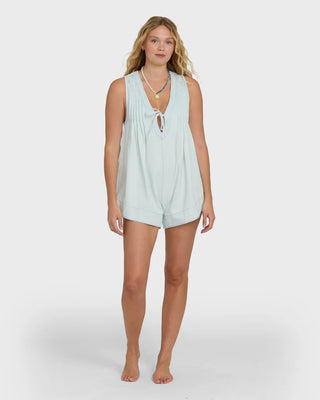 Woman wearing a light blue sleeveless top and shorts on a white background