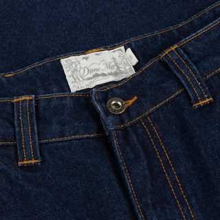 Front view of Dime Baggy Wink Denim Pants in dark Indigo with wide legs, contrast stitching, Western pockets, belt loops, and an embroidered front-pocket logo