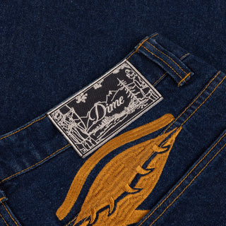 Front view of Dime Baggy Wink Denim Pants in dark Indigo with wide legs, contrast stitching, Western pockets, belt loops, and an embroidered front-pocket logo