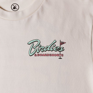 Drift House Birdies & Boardshorts Tee in Ecru, featuring a Space Coast golf benefit back graphic with surfboards, palm trees, and a rocket.