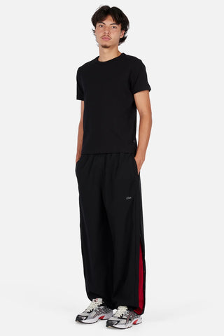 Dime Athletic Snap Pants in Black/Red — polyester/spandex blend with snap side seam plackets, integrated pockets, contrast mesh lining, 3M branding, cinched leg openings, and elasticated speckled drawstring waistband
