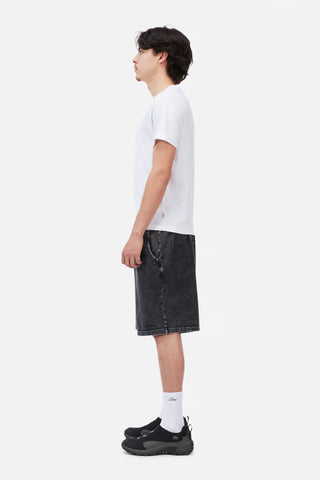 Person wearing a white t-shirt and black denim shorts on a white background