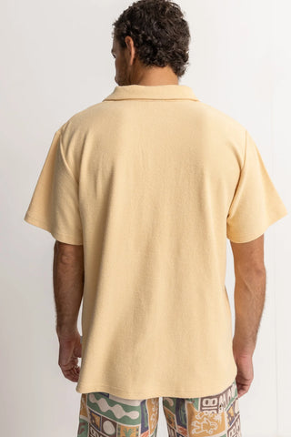 Sand-colored vintage terry polo with chest pocket and soft texture.