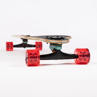“End view of the Sector 9 9er Mini Fractal showing the layered maple deck, black Gullwing truck, and translucent red wheels.”