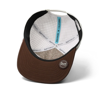melin Coronado Brick Hydro Hat in Frosted Birch with an off-white crown, brown flat visor, rectangular melin patch, patterned rope trim, and perforated side panels.