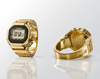 Gold Casio watch and ring on a white background