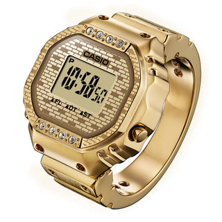 Gold Casio digital watch with brick pattern on a white background