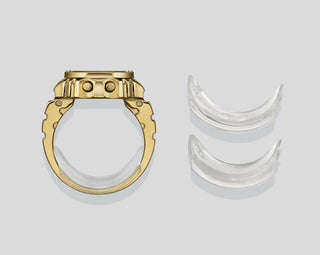 Gold ring and silver crescent-shaped objects on a light gray background