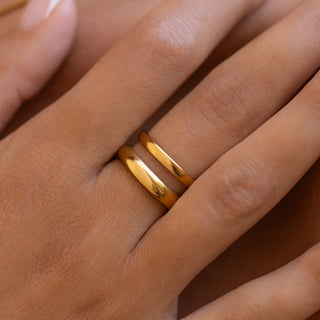 Gold sculptural ring with flowing ocean-inspired curves.