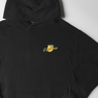 Drift House Fresh Squeezed Hoodie in Vintage Black — relaxed garment-dyed 9.4 oz fleece pullover with Florida orange front graphic, "Fresh Squeezed Threads" back print, drop shoulders, and kangaroo pocket
