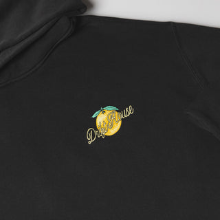 Drift House Fresh Squeezed Hoodie in Vintage Black — relaxed garment-dyed 9.4 oz fleece pullover with Florida orange front graphic, "Fresh Squeezed Threads" back print, drop shoulders, and kangaroo pocket